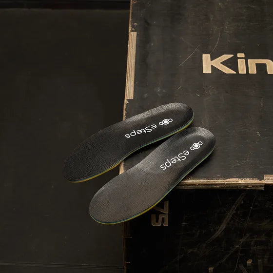 The eSteps insoles balanced on the corner of a wooden crate.