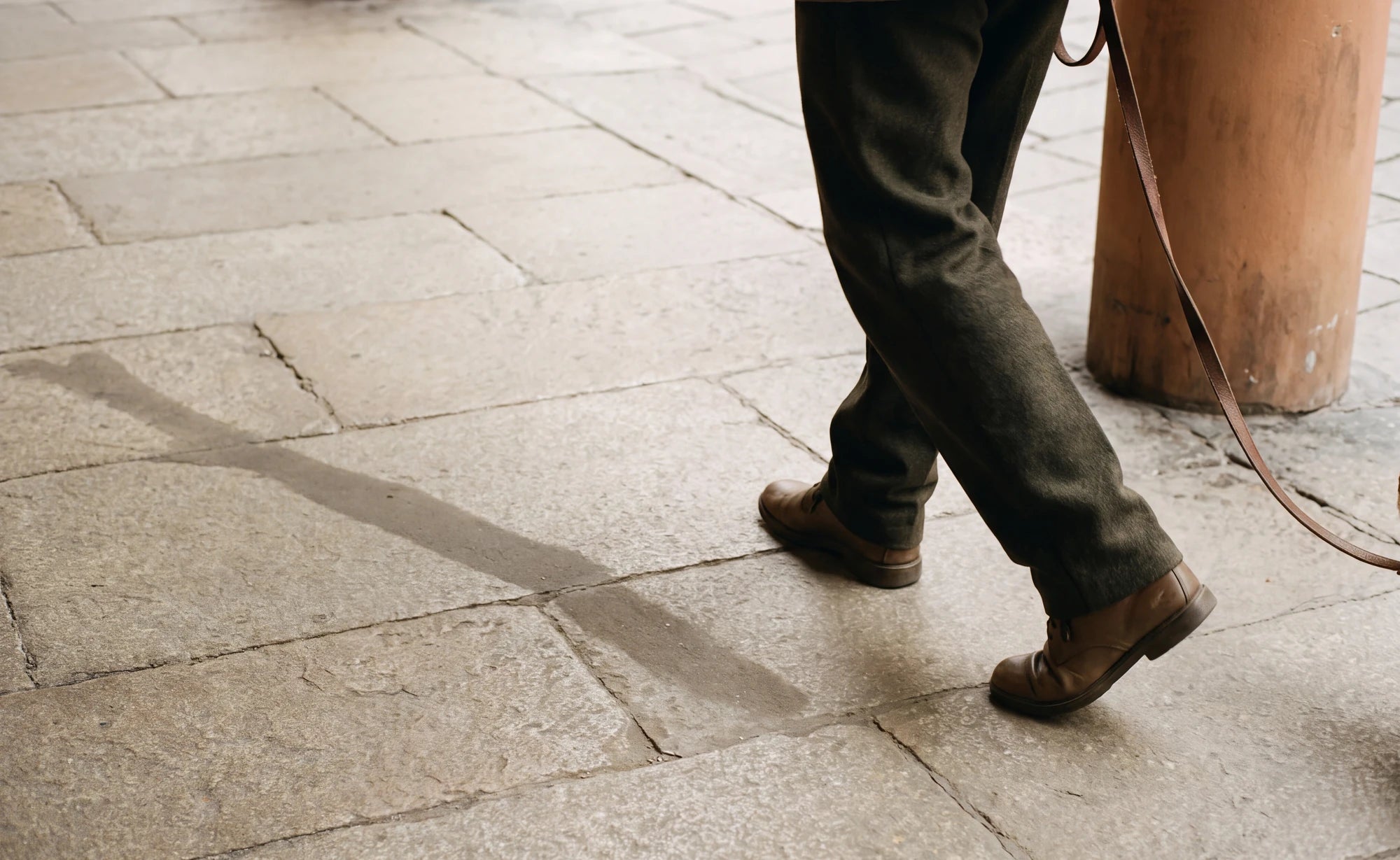 Three people walking a street together, seen from the knees down.