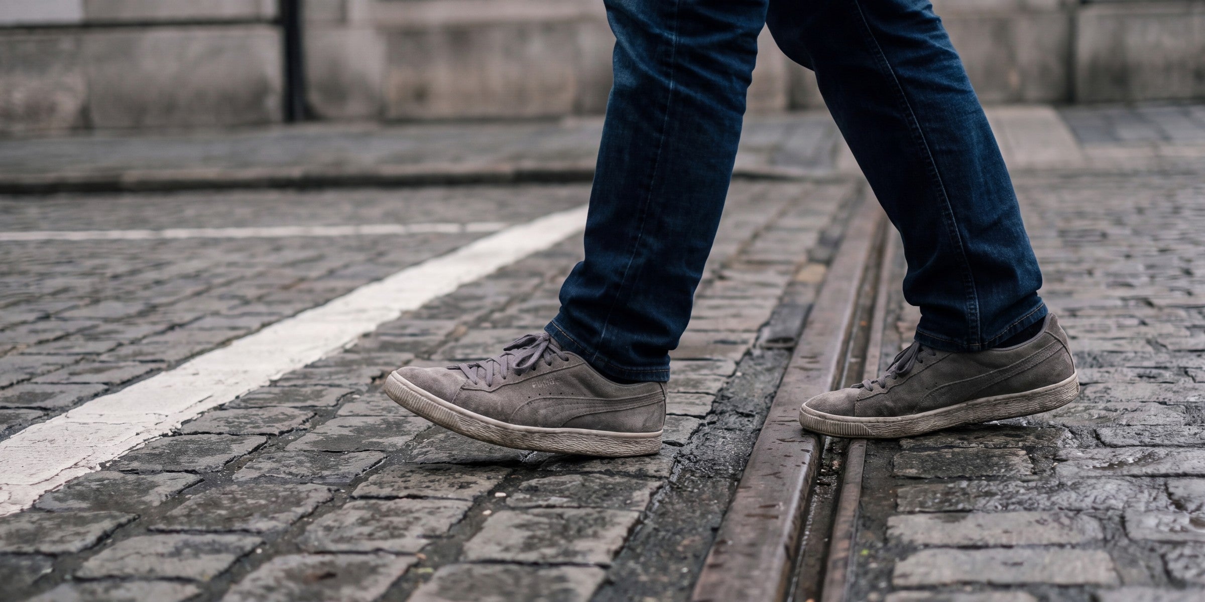 Someone walking along a pavement in ordinary shoes.